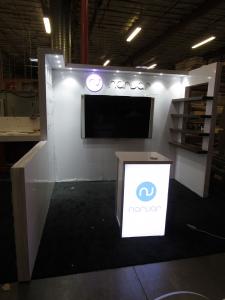 Custom Inline Exhibit with Laminate Finish, Puck Lights, Floating Shelves, Return Walls, and MOD-1701 Backlit Counter with Shelf and Locking Storage